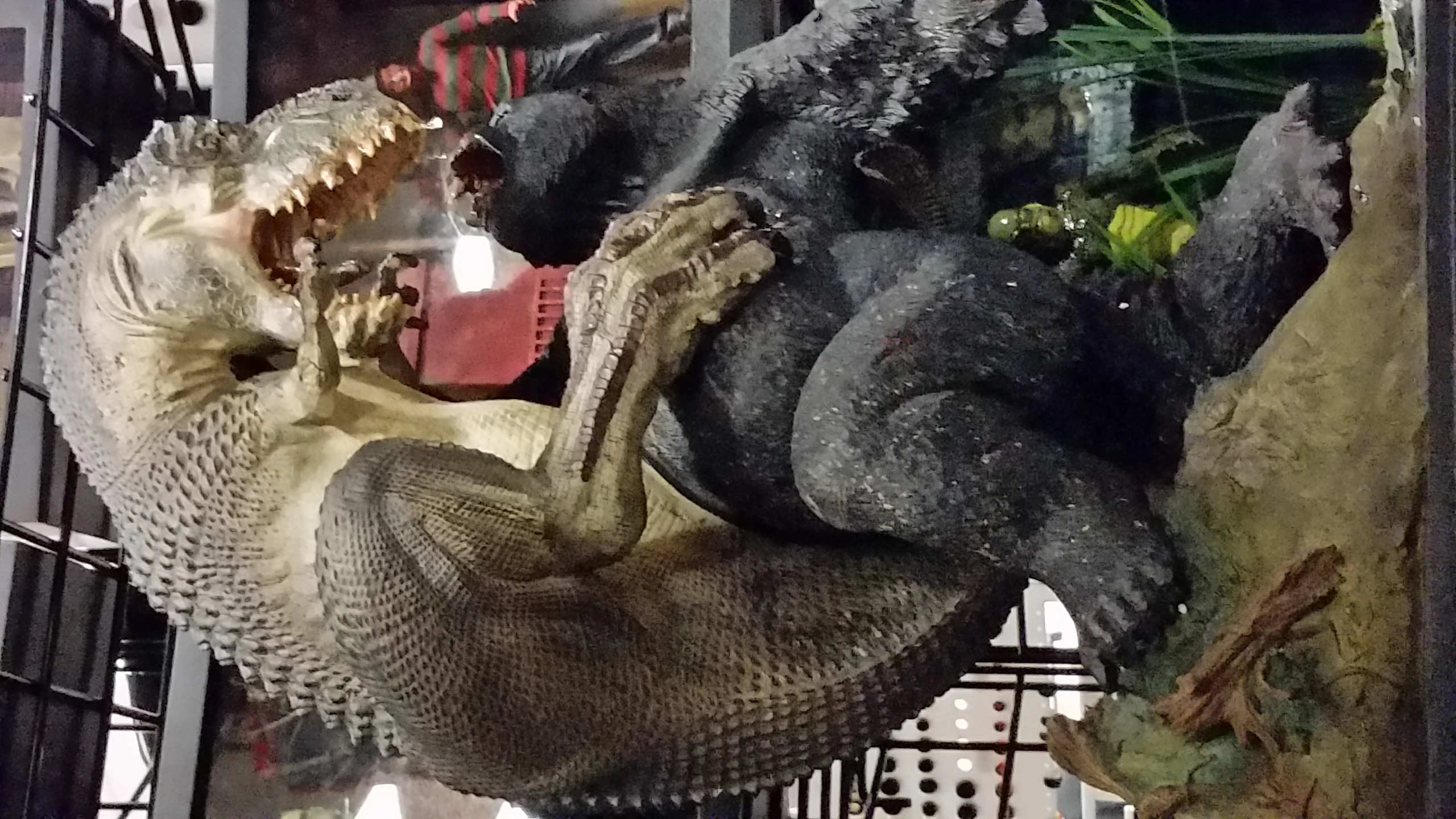 a godzilla is posed next to two gorilla figurines