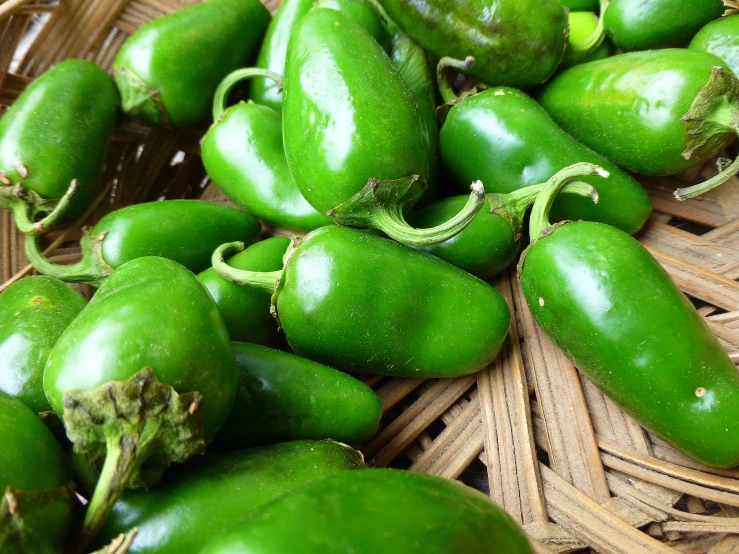 several green peppers on a woven basket