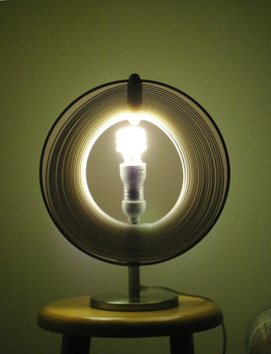 the reflection of an illuminated bulb under a desk lamp