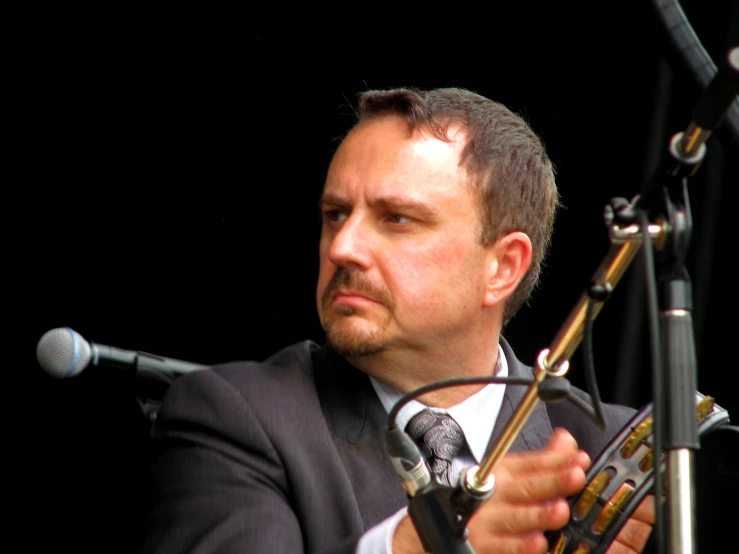 a man playing the instrument in front of microphones