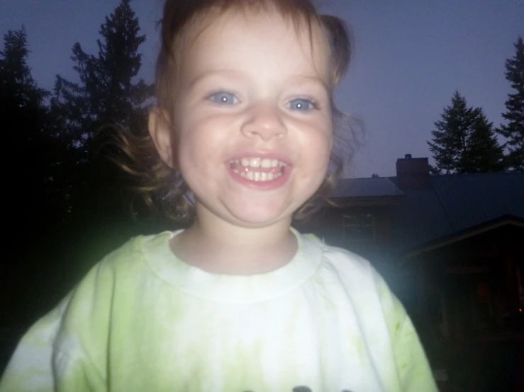 a young child smiles as it's wearing green
