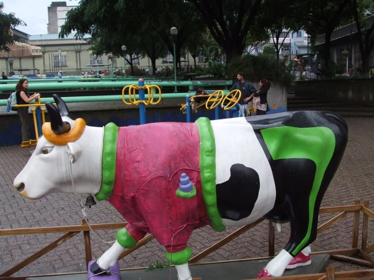 there are cows with costume on them standing on the sidewalk