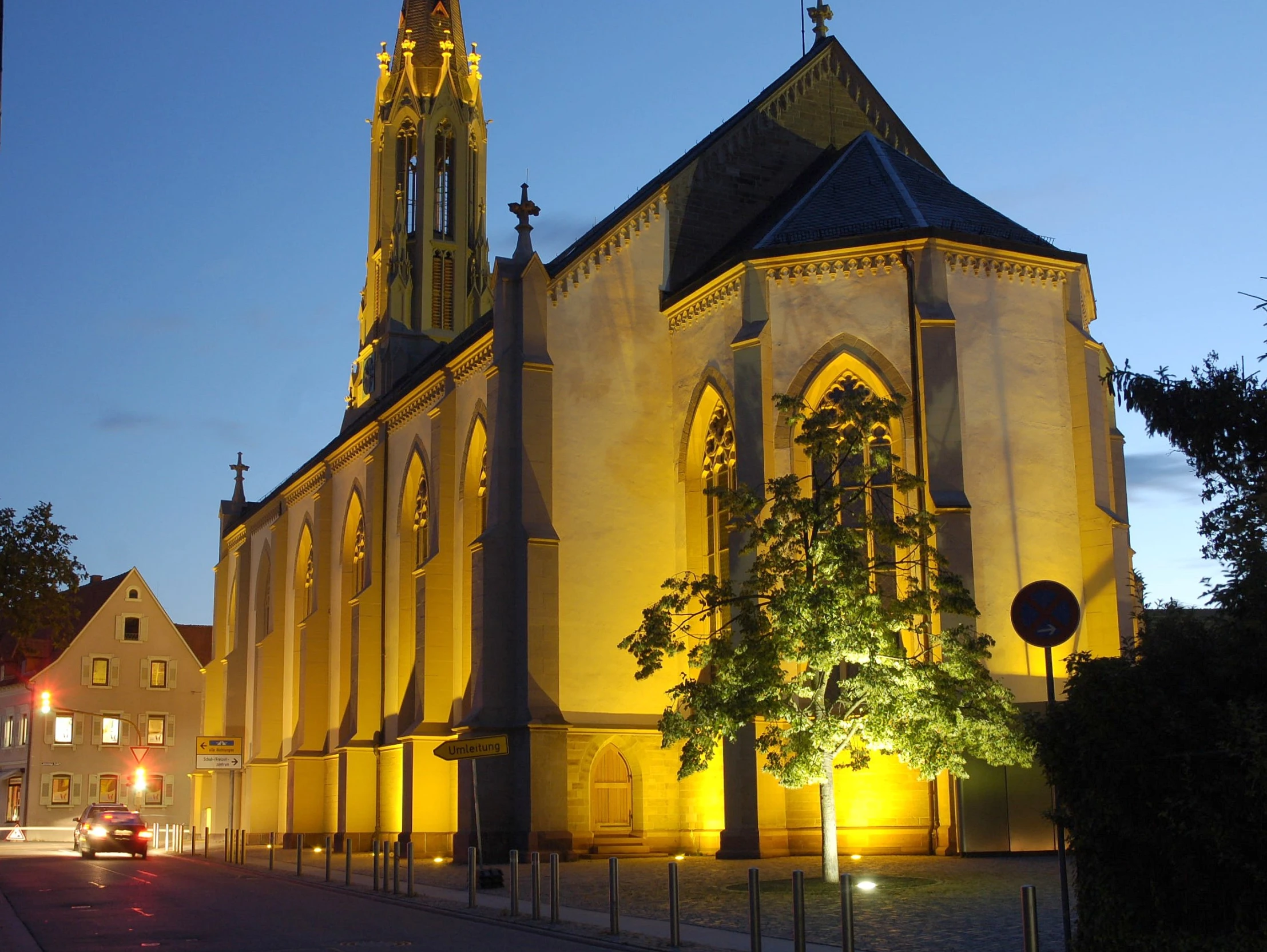 an ornate church with a tall tower in the evening