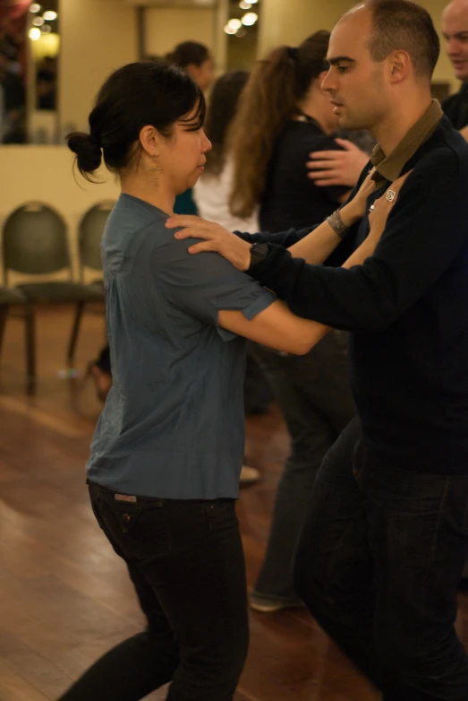 a man and woman are dancing together in the dance hall