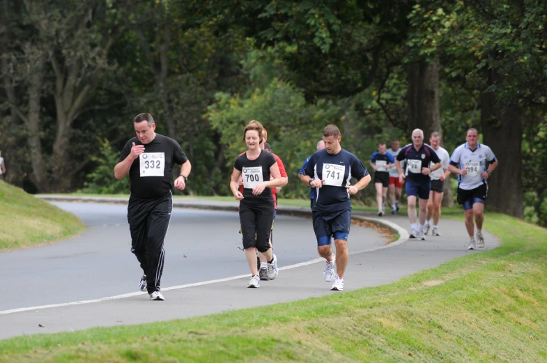 a group of runners are running down a country road