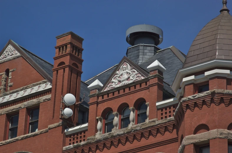 two clocks are hanging off the side of a building