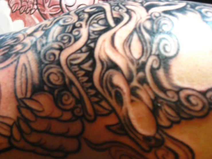an inky design on a man's back shoulder