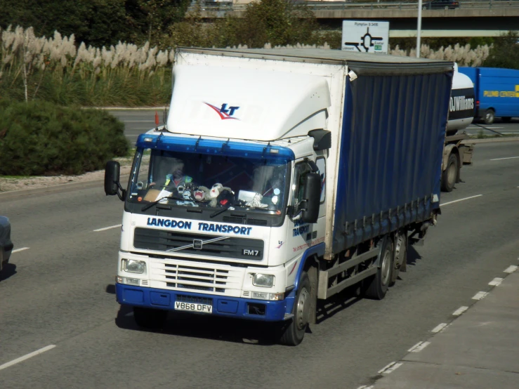 large truck with blue trim driving down a road