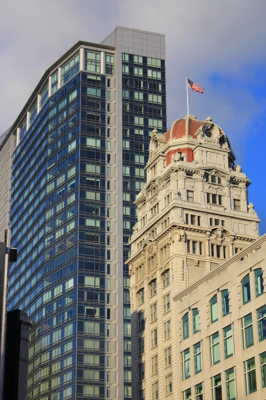 two building towers with a flag on each side