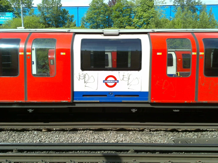 an orange, white and blue train stopped at a platform