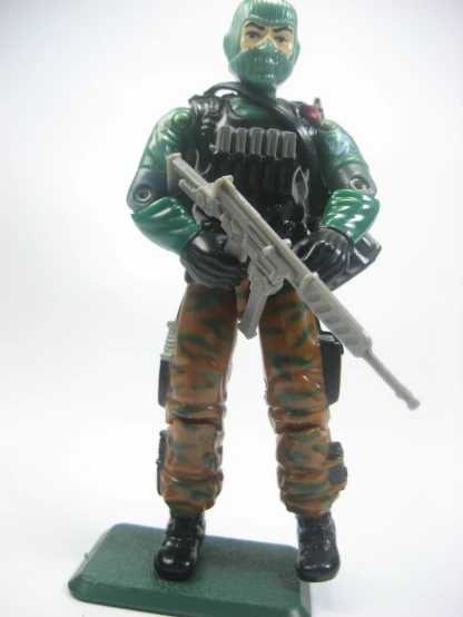 the toy soldier is holding a gun on a base