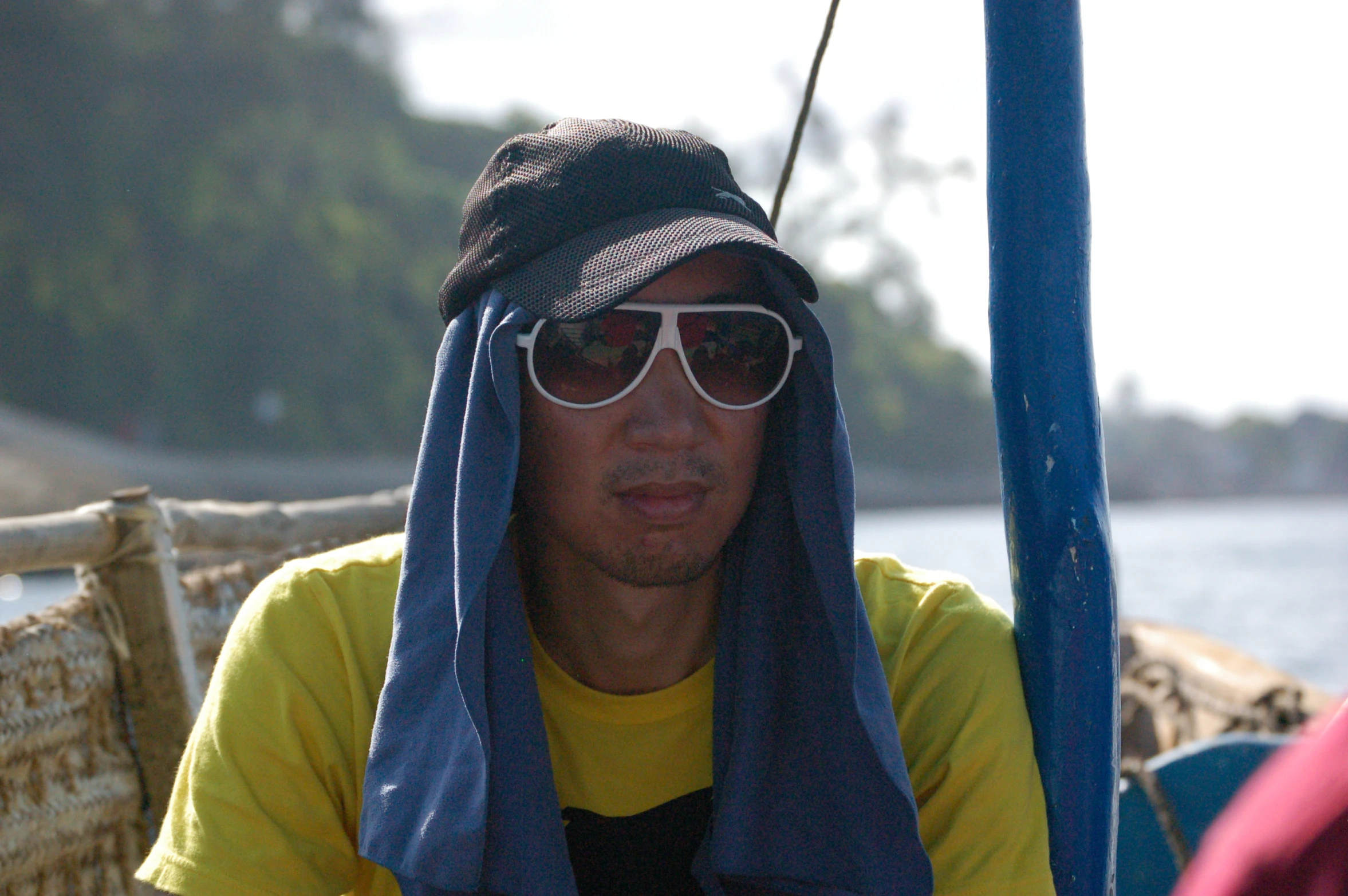 a man on a boat wearing a blue towel over his head