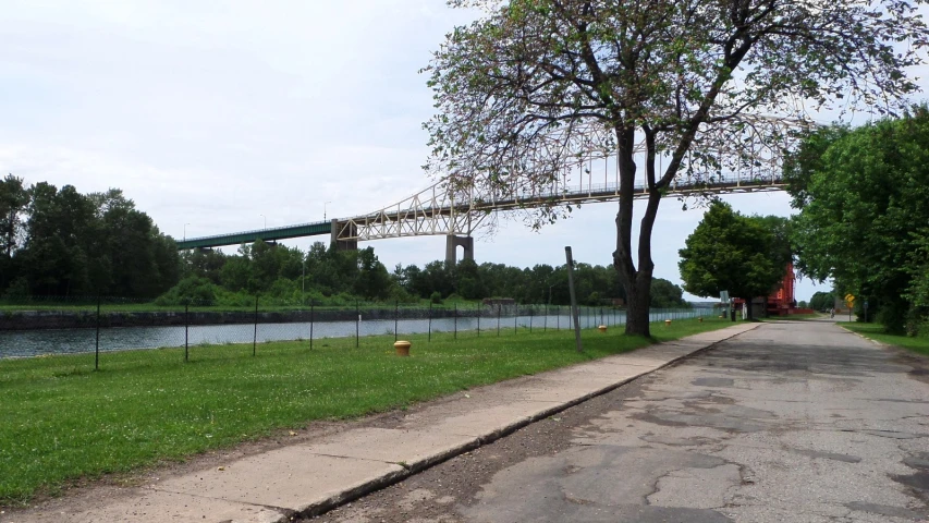 an empty path on the side of the road leading to a river