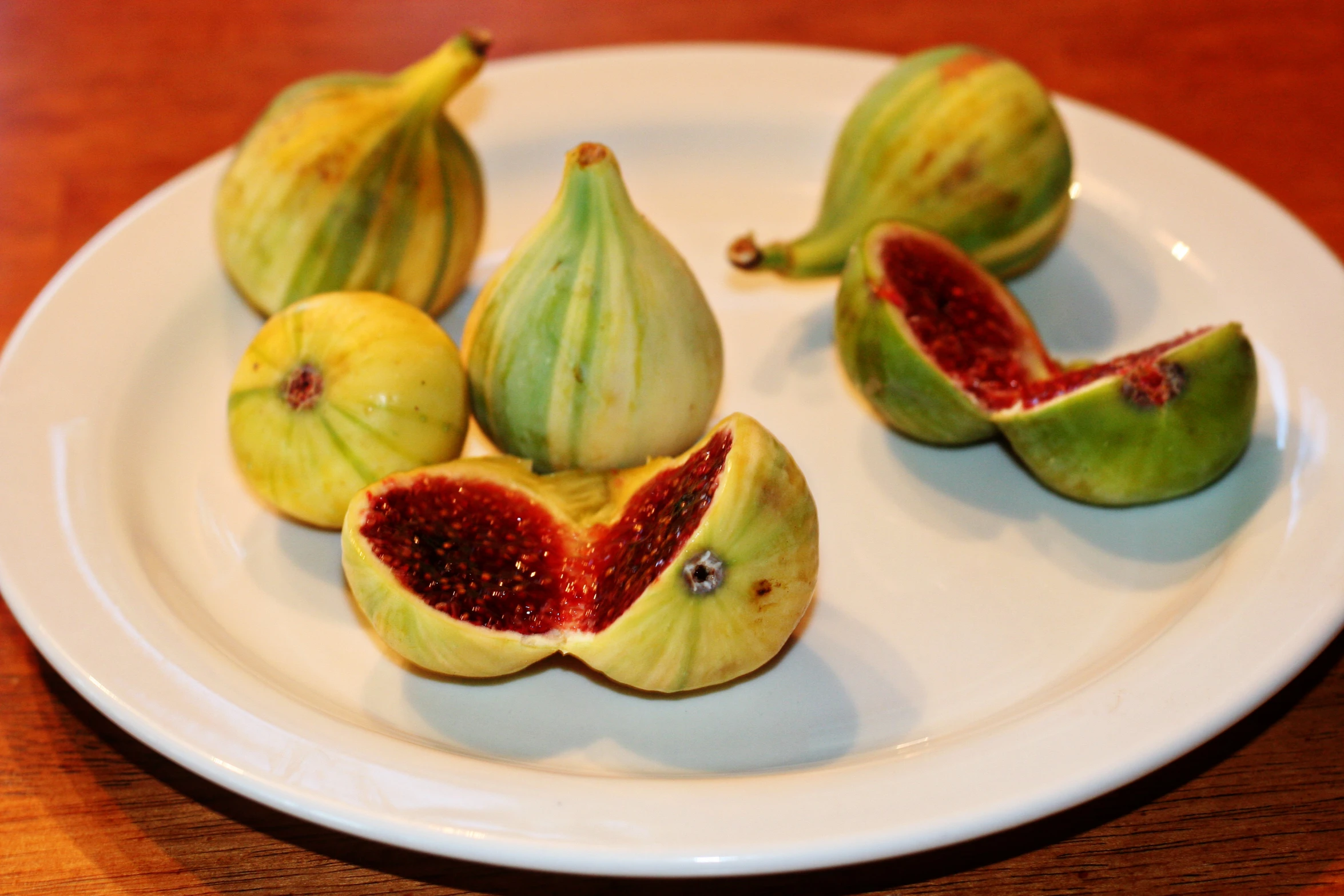 this is a plate with pieces of figs and some cut in half