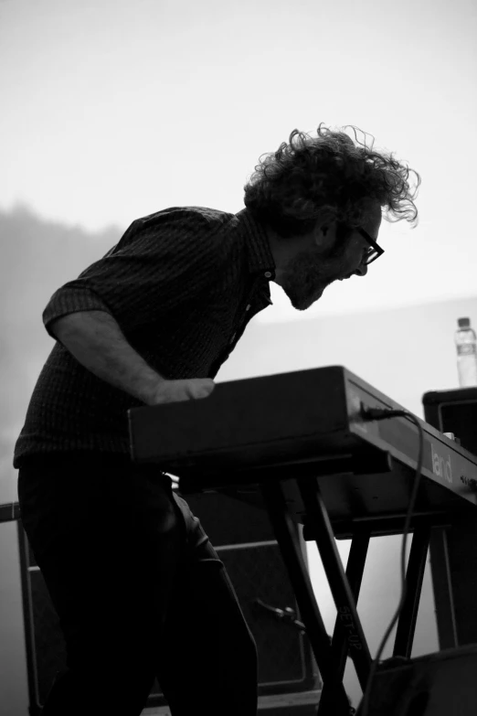 a man is playing an electronic keyboard at a concert