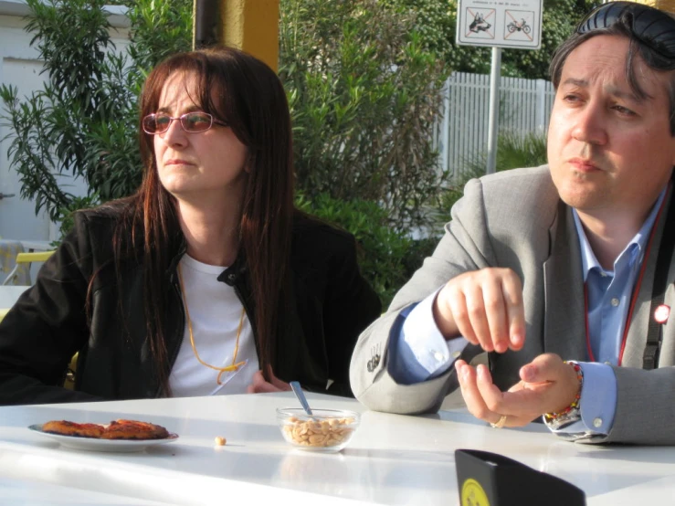 a couple at an outdoor dinner table eating a meal