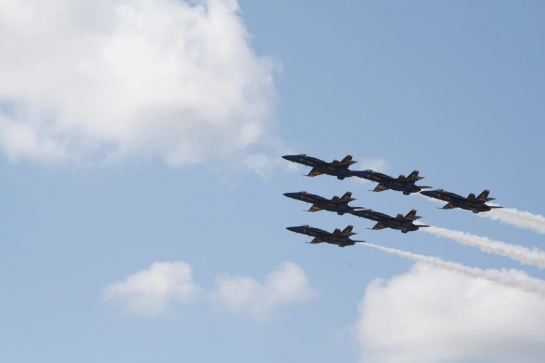 four jet airplanes are flying in formation in the sky