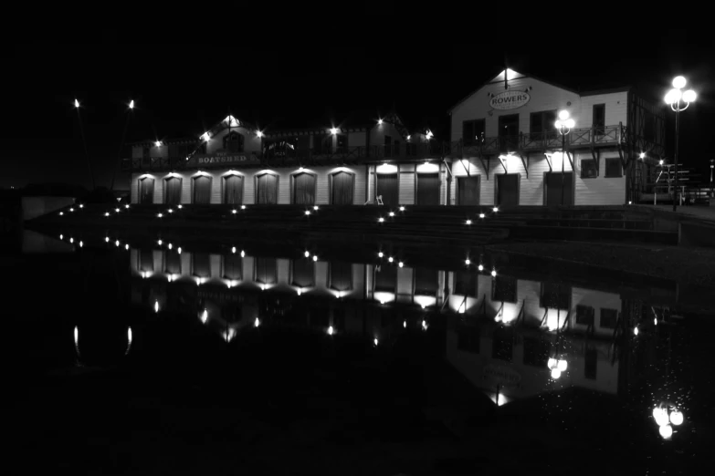 the water's edge reflects the lights and a clock on a building