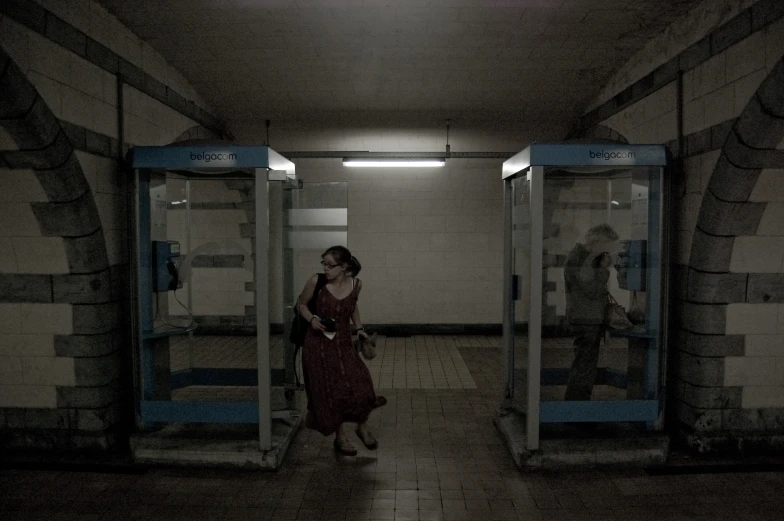 a woman standing inside a cell phone booth