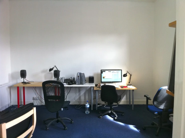 a view of a room from behind two computer monitors
