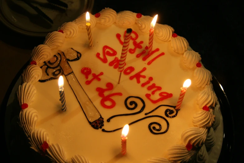 a birthday cake with a pair of scissors for 2 and 3 candles