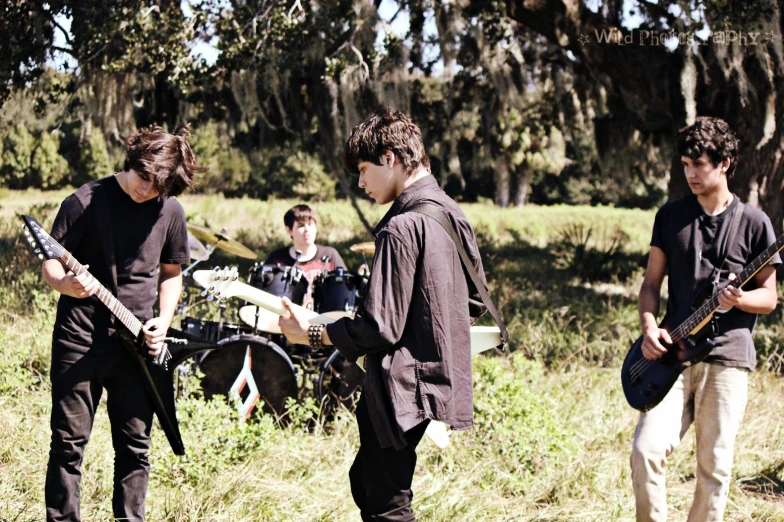 the boys are playing instruments in the grassy area