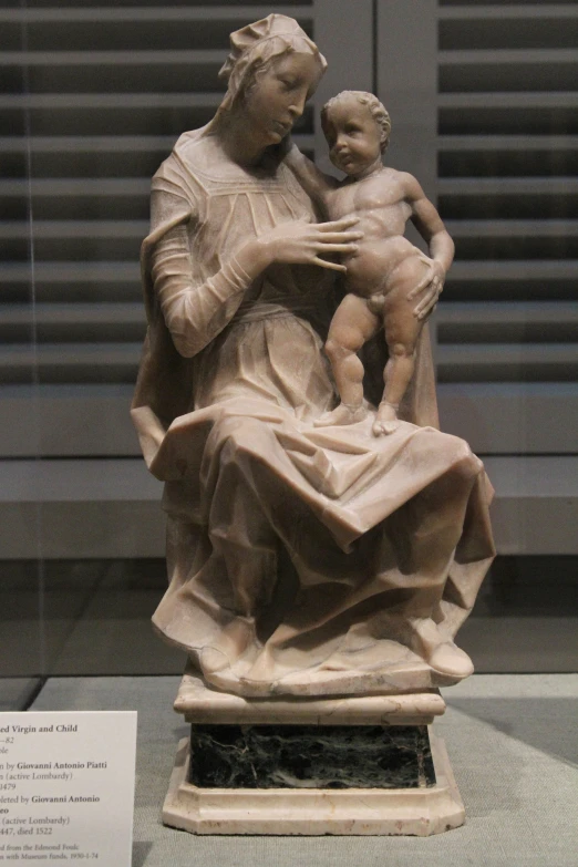 a marble statue of a woman holding a child