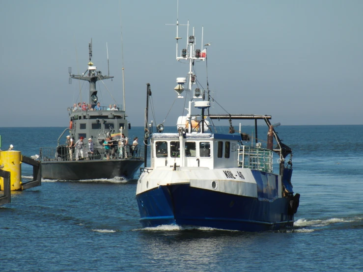 two boats on water near a dock with blue water