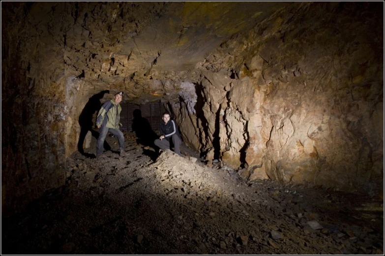 a couple of people walking inside of a cave