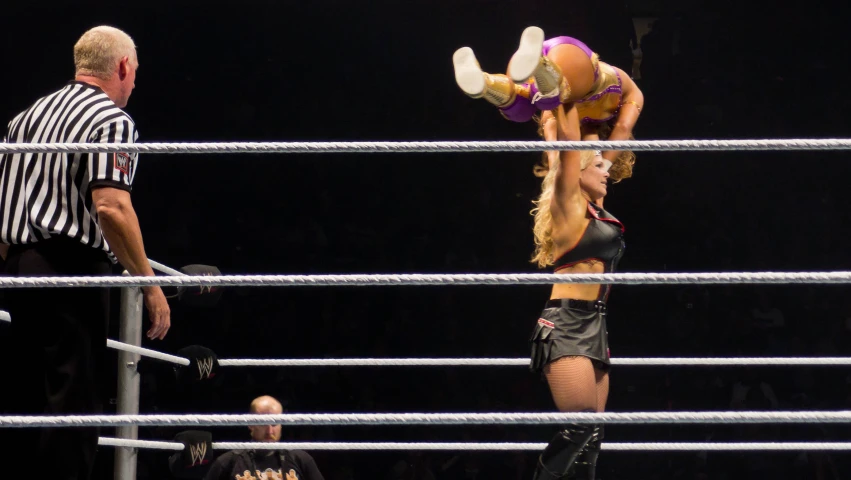 a woman on top of a wrestling ring