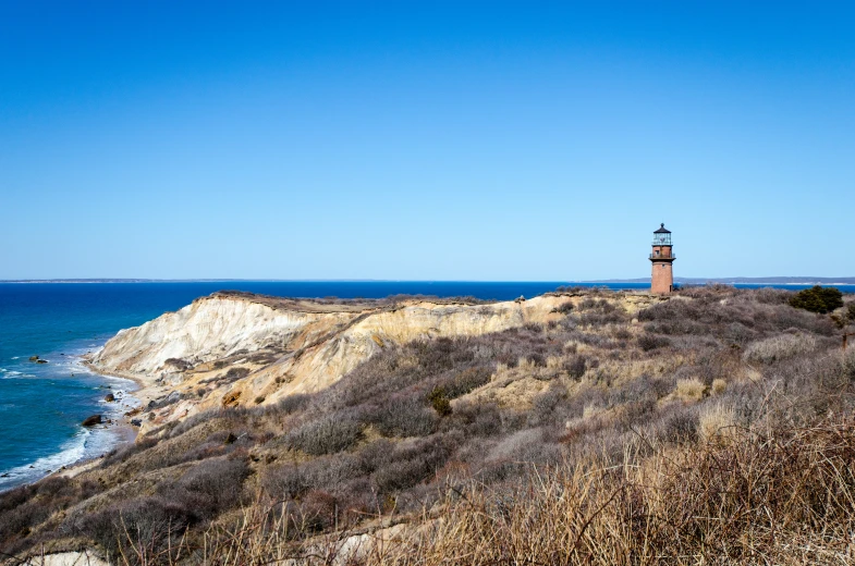 a lighthouse overlooking the ocean on a sunny day