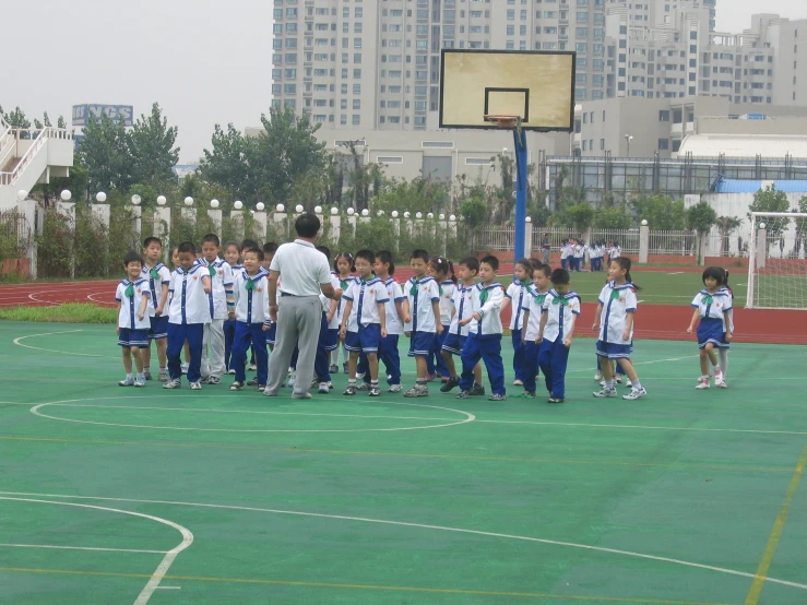 a group of boys are gathered around coach on a court