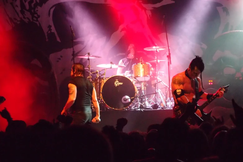 two men with their guitars performing on stage