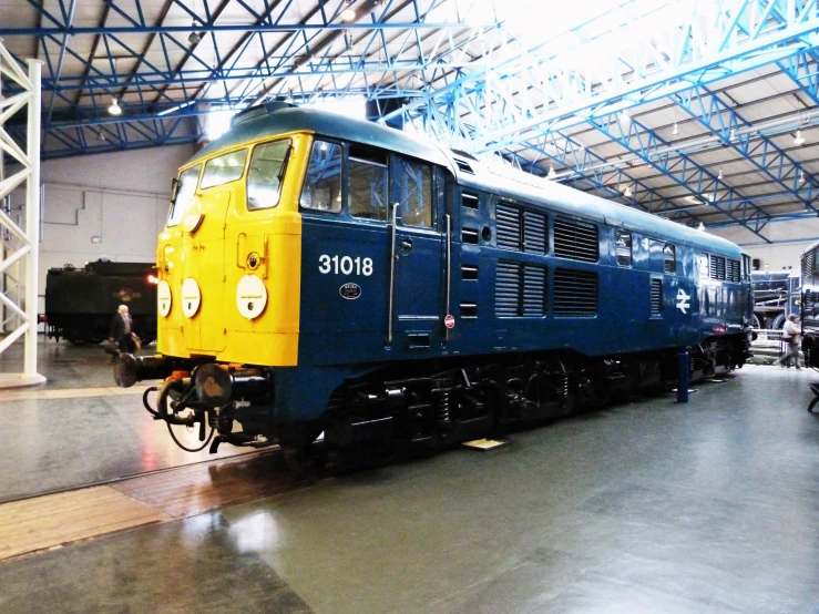 this is an old blue and yellow train in a museum