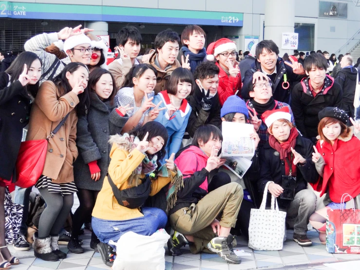 a group of people holding their hand up and showing the ok sign