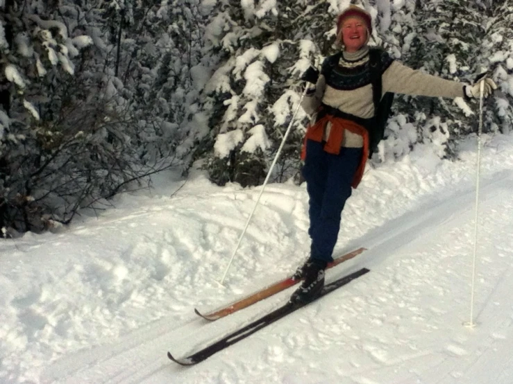 a woman is walking through the snow while holding ski poles