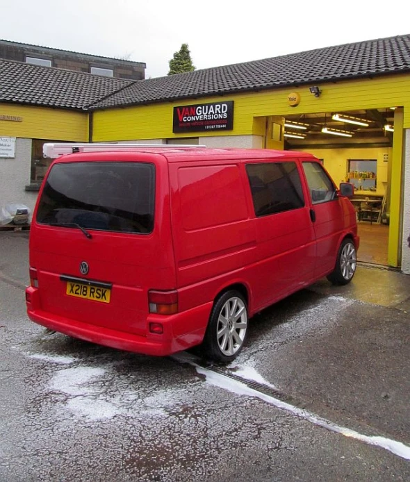 an orange van parked outside of a yellow building