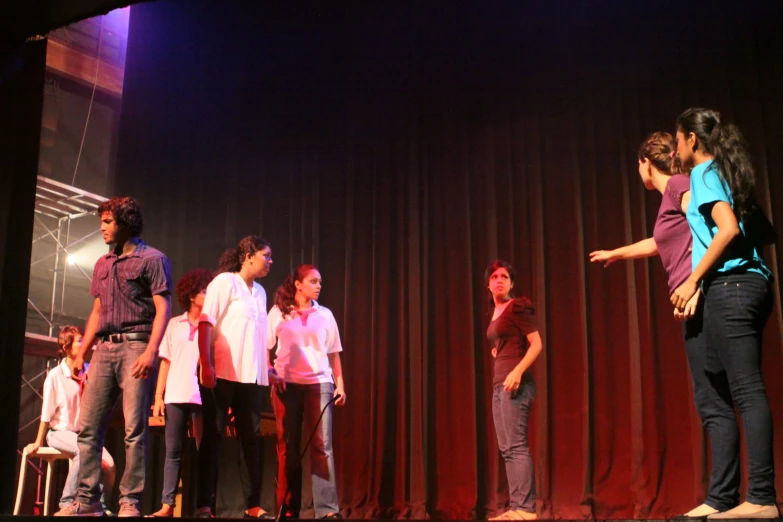 five students on stage are performing a variety of things