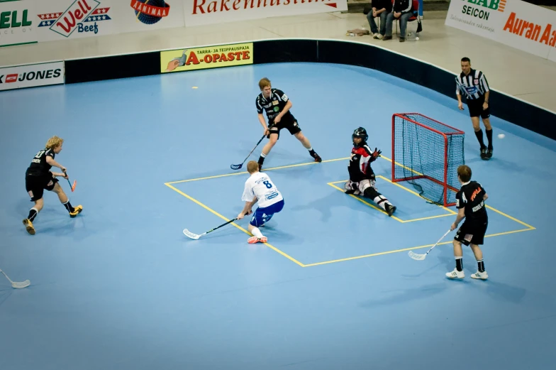 men in uniforms playing hockey on a blue court