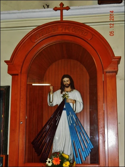 a statue of jesus holding the cross with flowers