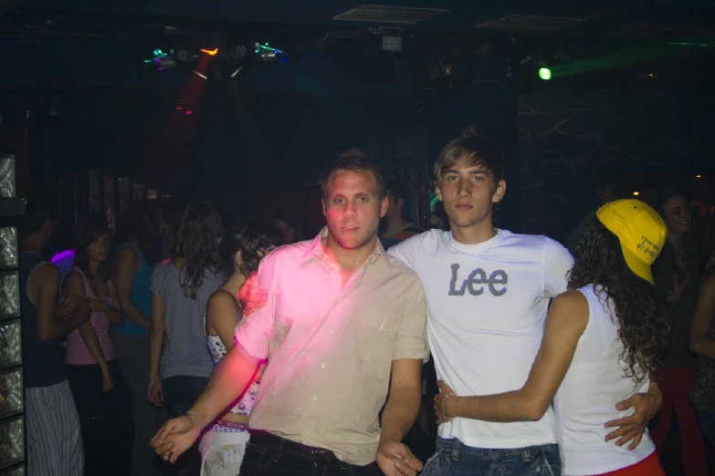 two young men with their arms around each other at a dance