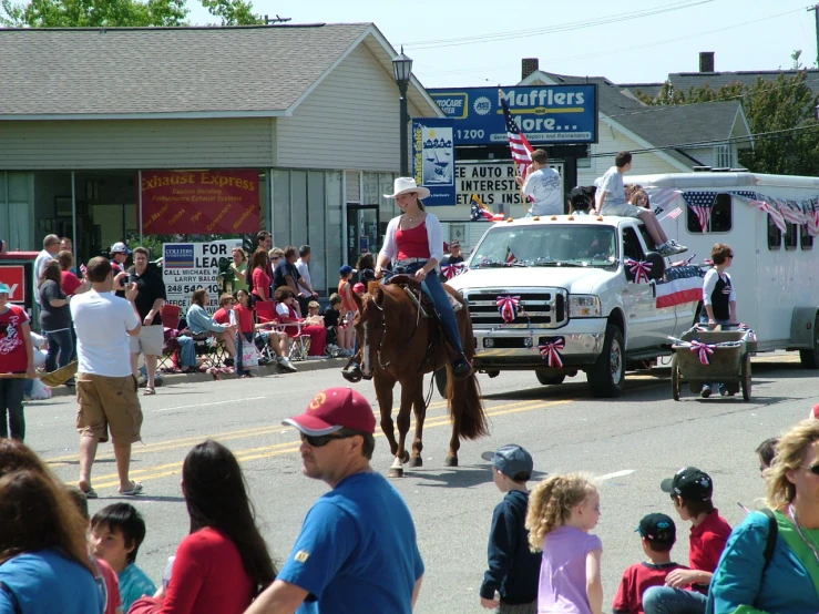 horse and carriage with parade participants in the street