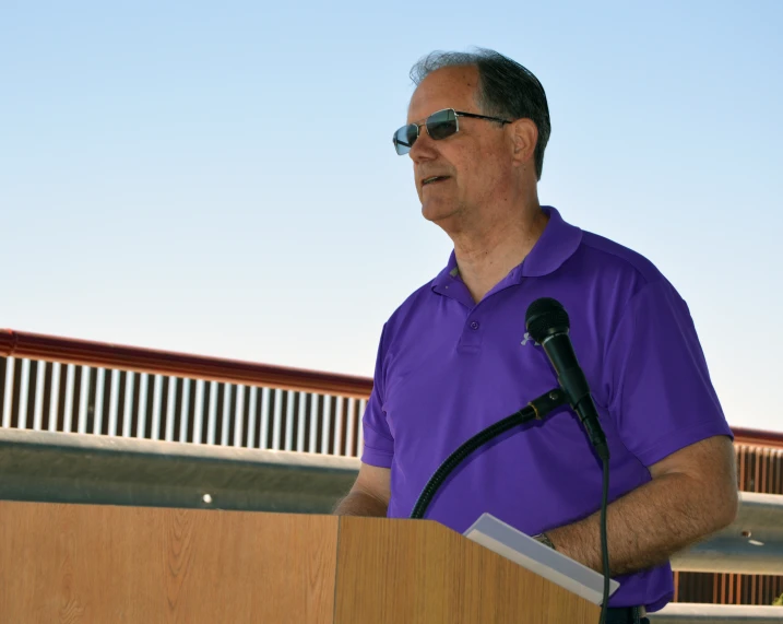 the man is standing behind a podium speaking