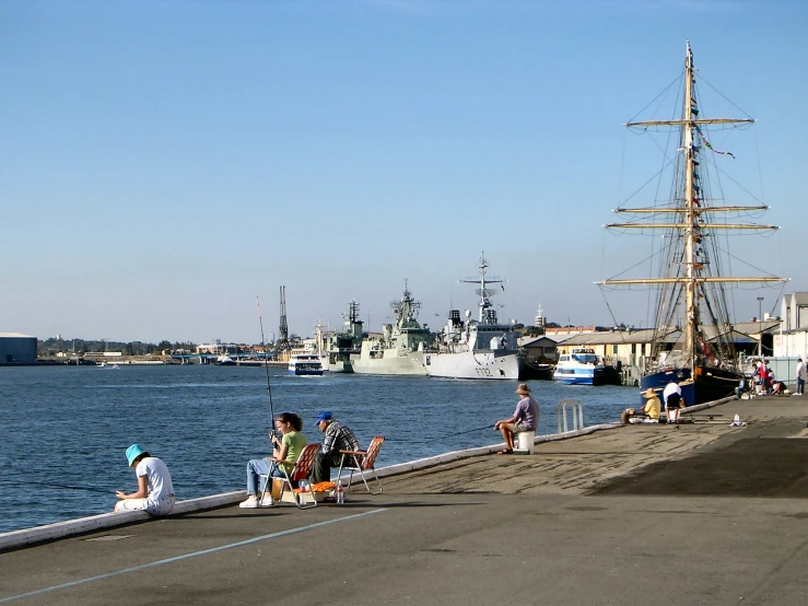 people standing by the side of a river near boats