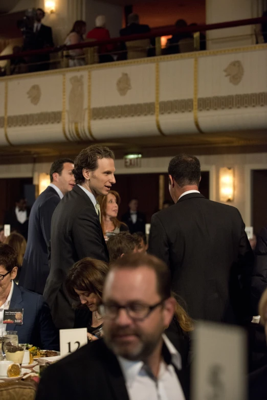 a large gathering of people sitting down at formal function