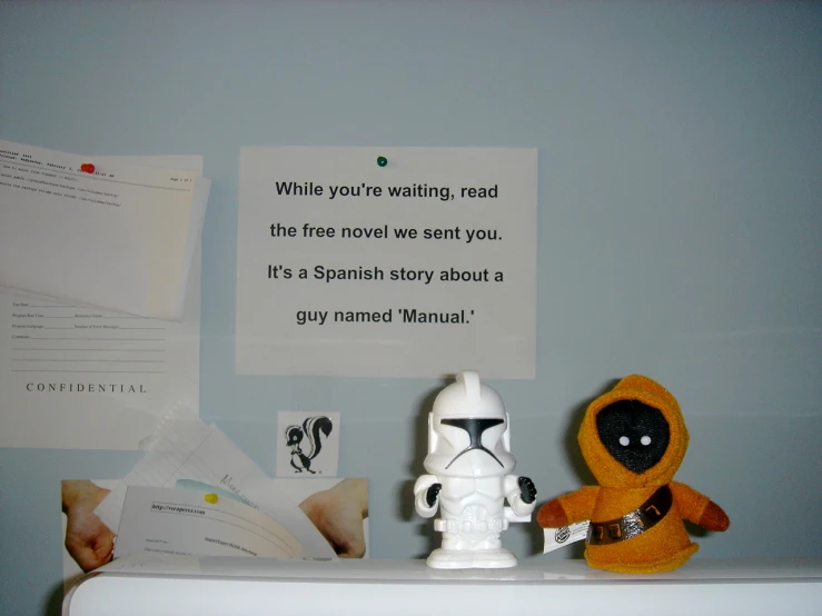 a star wars character sitting on a desk next to a lamp