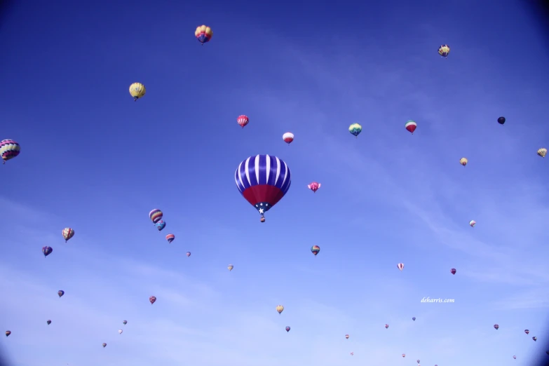 various balloons in the sky that are flying through the air