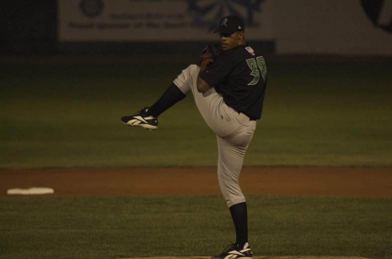 baseball pitcher in uniform pitching a baseball during a game