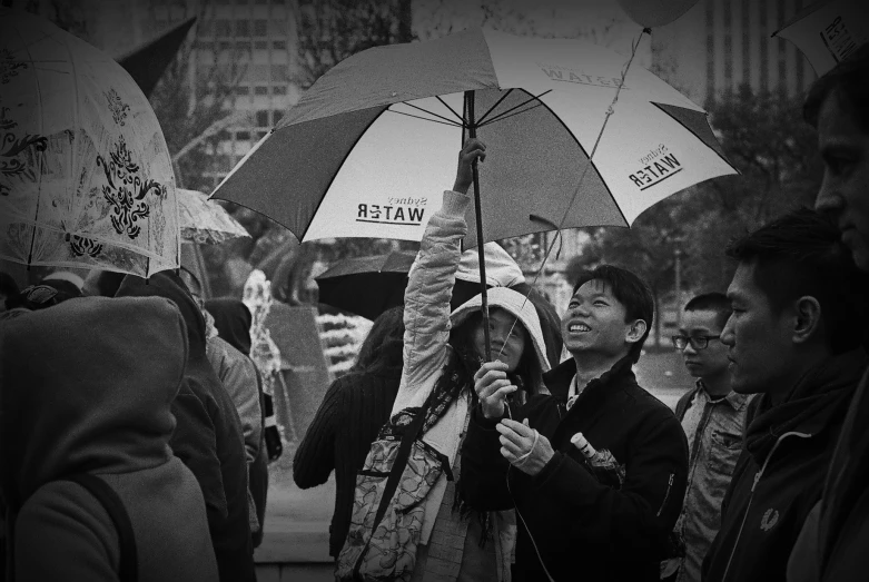 people with umbrellas standing on the sidewalk in the rain