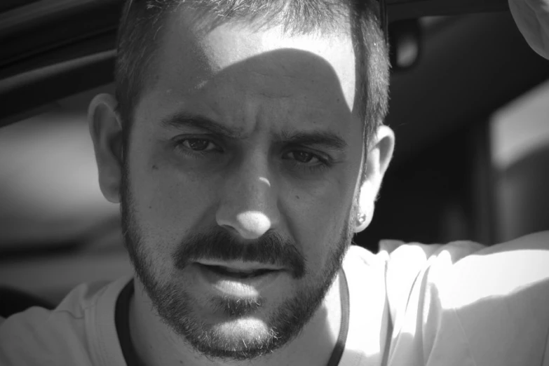 black and white pograph of a man sitting in a car